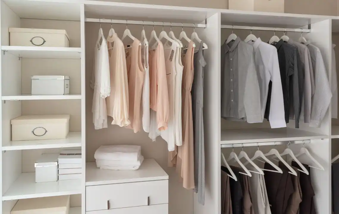 Custom closet design featuring organized clothing on hangers, neatly arranged shelves with storage boxes, and a clean aesthetic, reflecting tailored storage solutions for Cape Coral homes.